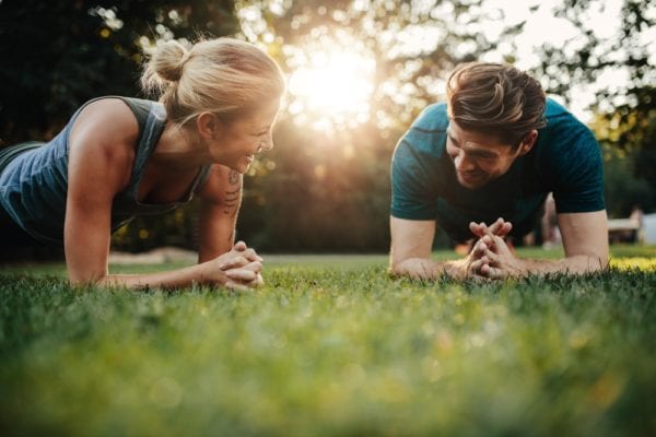 Fit Women and Fit Man Doing Joint Exercises in the Park