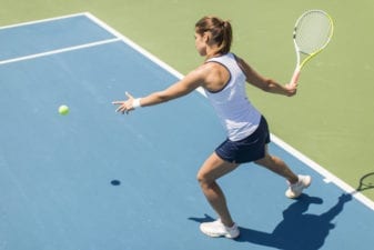Young women hitting a forehand on a tennis court