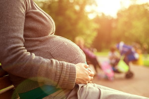 Pregnant women resting on a bench with joint pain