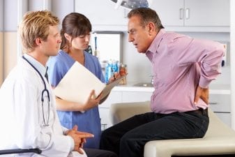 man speaking with doctor about his back pain